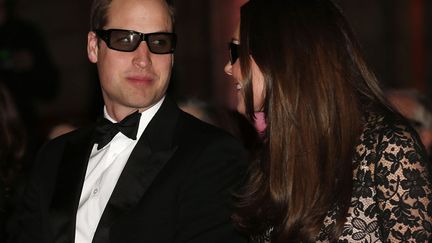 Le prince William (G) et son &eacute;pouse Catherine patientent avant le d&eacute;but de la projection d'un film en 3D au mus&eacute;e d'Histoire naturelle &agrave; Londres (Royaume-Uni), le 11 d&eacute;cembre 2013. (SUZANNE PLUNKETT / REUTERS)