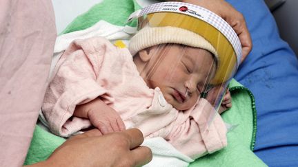 Un nouveau-né équipé d'une visière de protection, le 28 avril 2020, dans l'unité de néonatalogie de l'hôpital Mexico de San Jose (Costa Rica). (AFP)