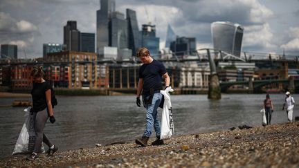 Des militants participent à un nettoyage de plage sur les rives de la Tamise, au centre de Londres, le 17 mai 2024. Photo d'illustration. (HENRY NICHOLLS / AFP)