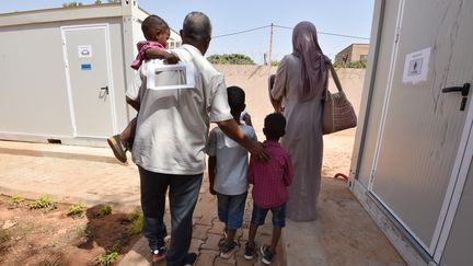 Des réfugiés marchent dans un bâtiment du HCR à Niamey (Niger), le 17 novembre 2017, après avoir été évacués de Libye. (SIA KAMBOU / AFP)