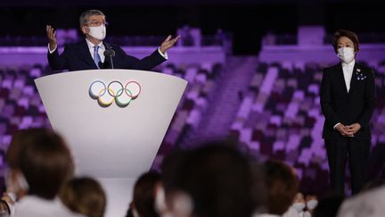 Le président du Comité international olympique, Thomas Bach, prononce le discours officiel d'ouverture&nbsp;des Jeux olympiques de Tokyo, avec la présidente du Comité d'organisation,&nbsp;Seiko Hashimoto. Quelques minutes plus tard, l'empereur du Japon, Naruhito, a officiellement déclaré l'ouverture de cette quinzaine olympique. (HANNAH MCKAY / AFP)