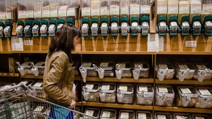 Une jeune femme fait ses courses dans un magasin bio, où elle peut acheter en vrac et utiliser ses propres emballages.&nbsp; (MARLENE AWAAD / MAXPPP)