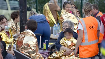 Des victimes et des membres de la SNCF &agrave; la gare de Br&eacute;tigny-sur-Orge (Essonne) apr&egrave;s le d&eacute;raillement du Paris-Limoges, le 12 juillet 2013. (MARTIN BUREAU / AFP)