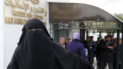 Une étudiante de l'université de Manouba (Tunisie) quitte le bâtiment après avoir refusé de quitter son niqab pendant des examens,&nbsp;le 24 janvier 2012. (FETHI BELAID / AFP)