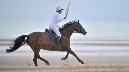 La flamme olympique est passée par la très célèbre plage de Omaha Beach (Calvados), le 30 mai 2024, à quelques jours du 80e anniversaire du Débarquement. (LOU BENOIST / AFP)