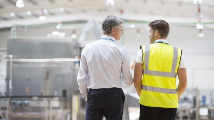 Un manager intermédiaire discute avec un salarié dans une entreprise. (MARTIN BARRAUD / CAIAIMAGE/ Getty Images)