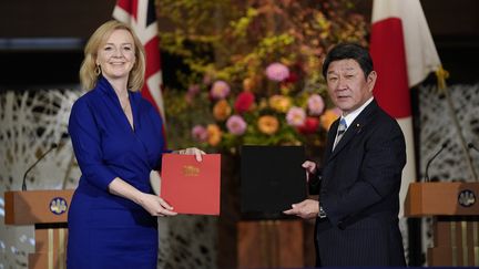 La ministre britannique du Commerce international, Liz Truss, et le ministre japonais des Affaires étrangères, Toshimitsu Motegi, lors de la signature&nbsp;d'un accord commercial bilatéral, le 23 octobre 2020 à Tokyo (Japon).&nbsp; (KIMIMASA MAYAMA / POOL / AFP)
