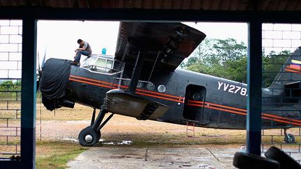 Les routes quasi inexistantes rendent l’accès à la province de Bolivar très difficile. Seules les pirogues ou les petits avions, comme les Antonov An-2, permettent de s’y rendre.

Ces avions, datant de l’ère soviétique, furent utilisés dans le monde entier. Robustes, économiques, ils permettent aujourd’hui de transporter le matériel vers les régions minières.

Mais, il n’est pas sans danger pour les pilotes, qui transportent souvent des tonnes de barils, d’atterrir sur les minuscules pistes boueuses. (REUTERS / Jorge Silva)