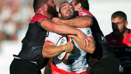 Le Toulousain Jean-Marc Doussain au contact de la défense toulonnaise, et Mamuka Gorgodze (BERTRAND LANGLOIS / AFP)