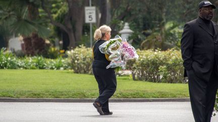 Une employée du cimetière Hollywood Forever Cemetery apporte des fleurs au cours des funérailles de L'Wren Scott, la compagne de Mick Jagger, le 25 mars 2014
 (JOE KLAMAR / AFP)