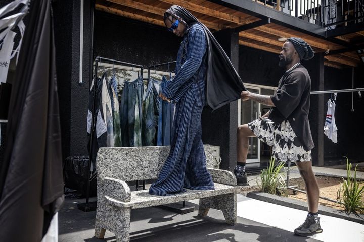 Moses Turahirwa ajuste l'une de ses créations sur un mannequin lors d'un essayage et d'une séance photo dans son studio de design à Kigali, le 9 avril 2024. (LUIS TATO / AFP)