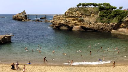 De baigneurs au&nbsp;rocher de la Vierge, sur la plage du Port-Vieux à Biarritz, le 17 juilet 2019 (PHILIPPE ROY / AFP)