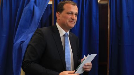 Louis Aliot, candidat FN &agrave; Perpignan, sort de l'isoloir du premier tour des municipales, le 23 mars.&nbsp; (RAYMOND ROIG / AFP)