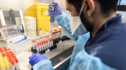 Un technicien de laboratoire s'occupe du séquençage de prélèvements positifs au Covid-19, au laboratoire de virologie de l'hôpital Henri-Mondor (AP-HP) de Créteil (Val de Marne), le 7 décembre 2021. (THOMAS SAMSON / AFP)