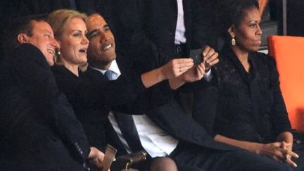 David Cameron, Helle Thorning-Schmidt et Barack Obama posent pour un "selfie", mardi 10 d&eacute;cembre au stade Soccer City de Soweto (Afrique du Sud), &agrave; l'occasion de la c&eacute;r&eacute;monie d'hommage &agrave; Nelson Mandela. (ROBERTO SCHMIDT / AFP)