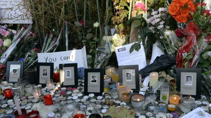 Le secrétariat général de l'aide aux victimes&nbsp;avait été créé après les attentats du 13 novembre 2015. Ci-contre, des bougies et des fleurs devant le Bataclan, à Paris, deux jours après les attaques. (MIGUEL MEDINA / AFP)