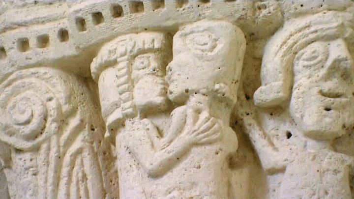 Un homme d'église embrasse lagoureusement une jeune femme (façade de l'église de Barret) 
 (France 3 / Culturebox)