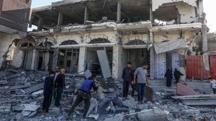 Des palestiniens cherchent les décombres d'un bâtiment détruit par une frappe israélienne à Khan Younès (bande de Gaza), le 30 octobre 2024. (ABED RAHIM KHATIB / ANADOLU / AFP)