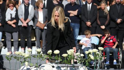 Les familles des victimes sont venues déposer des roses blanches à l'annonce des noms de leurs proches. (ERIC GAILLARD / AFP)