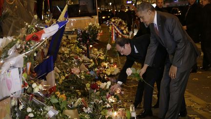 Barack Obama et François Hollande déposent une rose devant le Bataclan, dans la nuit du dimanche 29 au lundi 30 novembre 2015, à Paris. (PHILIPPE WOJAZER / REUTERS)