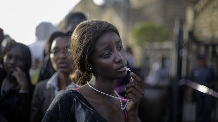 Premier prix cat&eacute;gorie "Portraits" : Une femme se tient devant l'acc&egrave;s ferm&eacute; &agrave; la d&eacute;pouille de l'ancien pr&eacute;sident sud-africain Nelson Mandela &agrave; Pretoria (Afrique du sud), le 13 d&eacute;cembre 2013. (MARKUS SCHREIBER / AP)