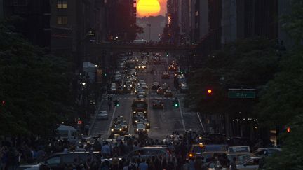 Une foule prend des photos du soleil se couchant dans la 42e rue &agrave; New York&nbsp;(Etats-Unis) &agrave; l'occasion de "Mahanttanhenge", le 29 mai 2013. (EDUARDO MUNOZ / REUTERS)