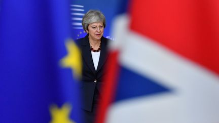 Theresa May, Premier ministre britannique vue à travers des drapeaux européen et britannique, à Bruxelles (Belgique). (EMMANUEL DUNAND / AFP)