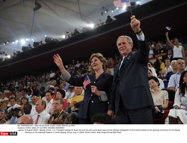 L'ancien président des Etats-Unis George W. Bush et son épouse Laura Bush saluent la délégation olympique&nbsp;américaine&nbsp;lors de la cérémonie d'ouverture des Jeux de Pékin au Stade national, le 8 août 2008. (CHINE NOUVELLE / SIPA)