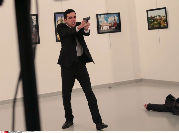 Le tireur d'Ankara qui a assassiné l'ambassadeur russe en Turquie gesticule après lui avoir tiré dessus pendant&nbsp;son discours d'inauguration d'une galerie d'art, le lundi 19 décembre. (BURHAN OZBILICI/AP/SIPA / AP)