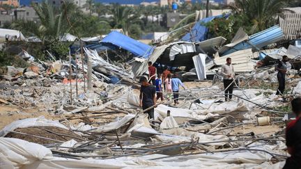 Des personnes recherchent des objets récupérables à la suite d'un raid israélien dans la région d'al-Mawasi à Rafah, dans le sud de la bande de Gaza, le 29 juin 2024. (EYAD BABA / AFP)