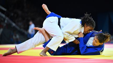 Sarah-Léonie Cysique (en blanc) a dû se remobiliser quelques minutes après son élimination en demi-finale pour remonter sur le tatami contre la Géorgienne Eteri Liparteliani, le 29 juillet 2024. Avec une réaction de championne, la native de Sarcelles (Val-d'Oise) est allé chercher le bronze en moins de 57 kg aux Jeux olympiques de Paris, après avoir déjà pris l'argent à Tokyo en individuel. (HAHN LIONEL / KMSP / AFP)