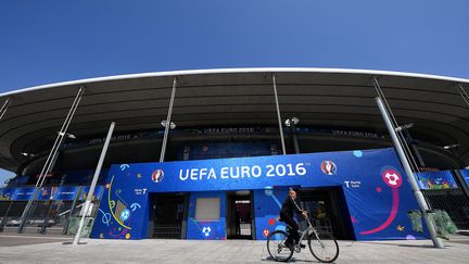 Un cycliste passe devant le Stade de France à la veille du match d'ouverture de l'Euro 2016, jeudi 9 juin 2016. (FRANCK FIFE / AFP)