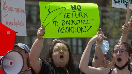 Des&nbsp;manifestantes&nbsp;en faveur du&nbsp;droit à l'avortement &nbsp;tiennent des pancartes en marge de la Marche nationale pour la vie à Ottawa, Ontario, le 12 mai 2022. (LARS HAGBERG / AFP)