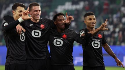 José Fonte, Sven Botman, Jonathan David et Reinildo à l'issue de la victoire contre Wolfsburg offrant la première place de leur groupe et la qualification en huitièmes de finale de la Ligue des champions au Losc, mercredi 8 décembre 2021. (RONNY HARTMANN / AFP)