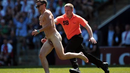 Un "streaker" traverse le terrain lors d'un match international de rugby opposant l'Angleterre &agrave; La Barbade &agrave; Londres (Royaume-Uni), le 26 mai 2013. (CARL COURT / AFP)