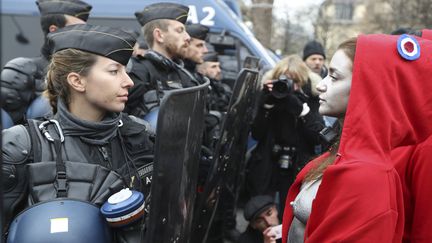 Une policière fait face à l'artiste Deborah de Robertis, habillée en Marianne, lors d'une manifestation des "gilets jaunes" à Paris, le 15 décembre 2018. (VALERY HACHE / AFP)