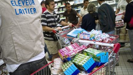 Des producteurs de lait vident les rayons de produits laitiers des rayons d'un supermarché, le 03 août 2010 à Dijon. (AFP - Jeff Pachoud)