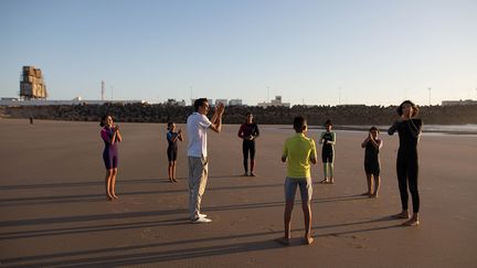 Sur la plage, M'barek El Fakir (en noir) explique les premiers gestes à accomplir avant de se jeter à l’eau. Des vidéos et des photos seront ensuite partagées sur réseaux sociaux du club.&nbsp; &nbsp; &nbsp; (REUTERS / IMANE DJAMIL)