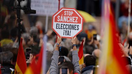 Un manifestant brandit une pancarte avec l'inscription "Stop Sanchez, élections maintenant !", lors d'une manifestation de l'extrême droite contre un projet d'amnistie pour les séparatistes catalans, à Madrid, le 29 octobre 2023. (OSCAR DEL POZO / AFP)