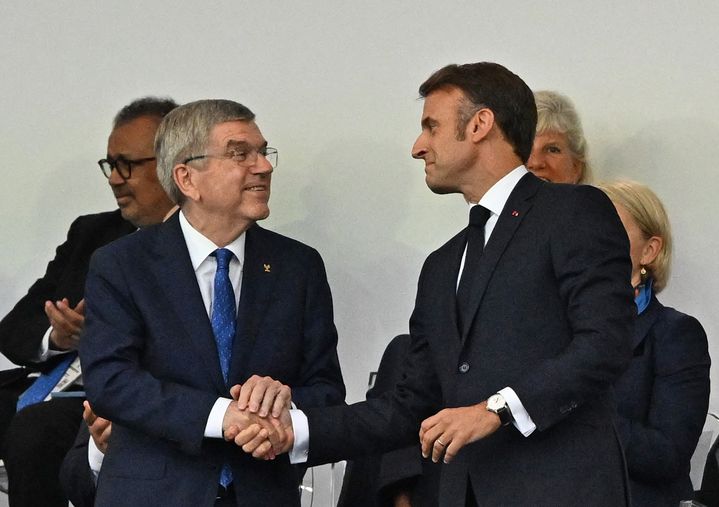 Le président français Emmanuel Macron salue Thomas Bach, le président du Comité international olympique, le 26 juillet 2024, lors de la cérémonie d'ouverture des Jeux. (TETSU JOKO / YOMIURI / AFP)