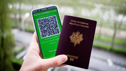 Un passeport français photographié&nbsp;avec un QR code attestant que son propriétaire n'est pas porteur&nbsp;du&nbsp;Sars-CoV-2. (VALENTINO BELLONI / HANS LUCAS / AFP)