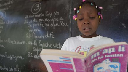 Haïti  : enfant lisant en classe un livre en créole (ici en 2013). 
 (Dieu Nalio Chery/AP/SIPA)