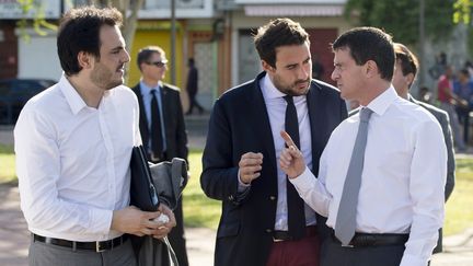 Manuel Valls, alors ministre de l'Int&eacute;rieur, avec ses deux plus proches collaborateurs, Harold Hauzy (&agrave; gauche) et S&eacute;bastien Gros (au centre). (MIGUEL MEDINA / AFP)