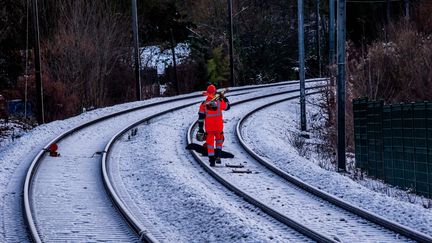 Un ouvrier travaille sur les voies ferrées sous la neige. Photo d'illustration. (MAXPPP)