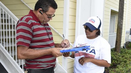 Les membres de l'association "My Familia Vota" font du porte-à-porte à Orlando&nbsp; (RHONA WISE / AFP)