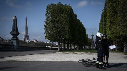 Un policier contrôle un homme à Paris, le 31 mars 2020 (illustration). (PHILIPPE LOPEZ / AFP)