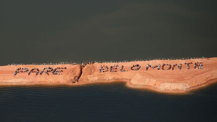 Des opposants &agrave; la construction du barrage de Belo Monte (Br&eacute;sil) forment le 15 juin 2012, le slogan "Pare Belo Monte" ("Stop &agrave; Belo Monte"), &agrave; l'endroit o&ugrave; il doit &ecirc;tre construit. (ATOSSA SOLTANI / AMAZON WATCH / AFP)