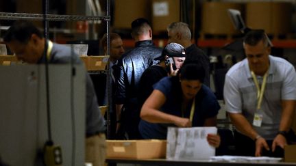 Des fonctionnaires vérifient le contenu des bulletins de vote dans un bureau de vote à Philadelphie, en Pennsylvanie, le 5 novembre 2024. (HEATHER KHALIFA / GETTY IMAGES NORTH AMERICA / AFP)