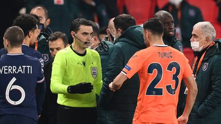 L'arbitre roumain Ovidiu&nbsp;Hategan discute avec le joueur du Basaksehir Istanbul, Demba Ba après la suspension du match contre le PSG, mardi 8 décembre 2020. (FRANCK FIFE / AFP)