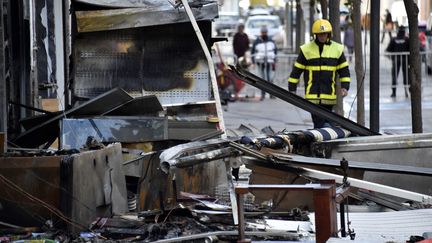 Un pompier marche près des décombres des immeubles incendiés à Saint-Laurent-de-la-Salanque (Pyrénées-Orientales), le 15 février 2022. (RAYMOND ROIG / AFP)